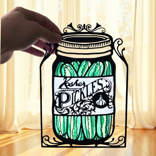 Pickle Jar papercut with tissue paper, light shining through