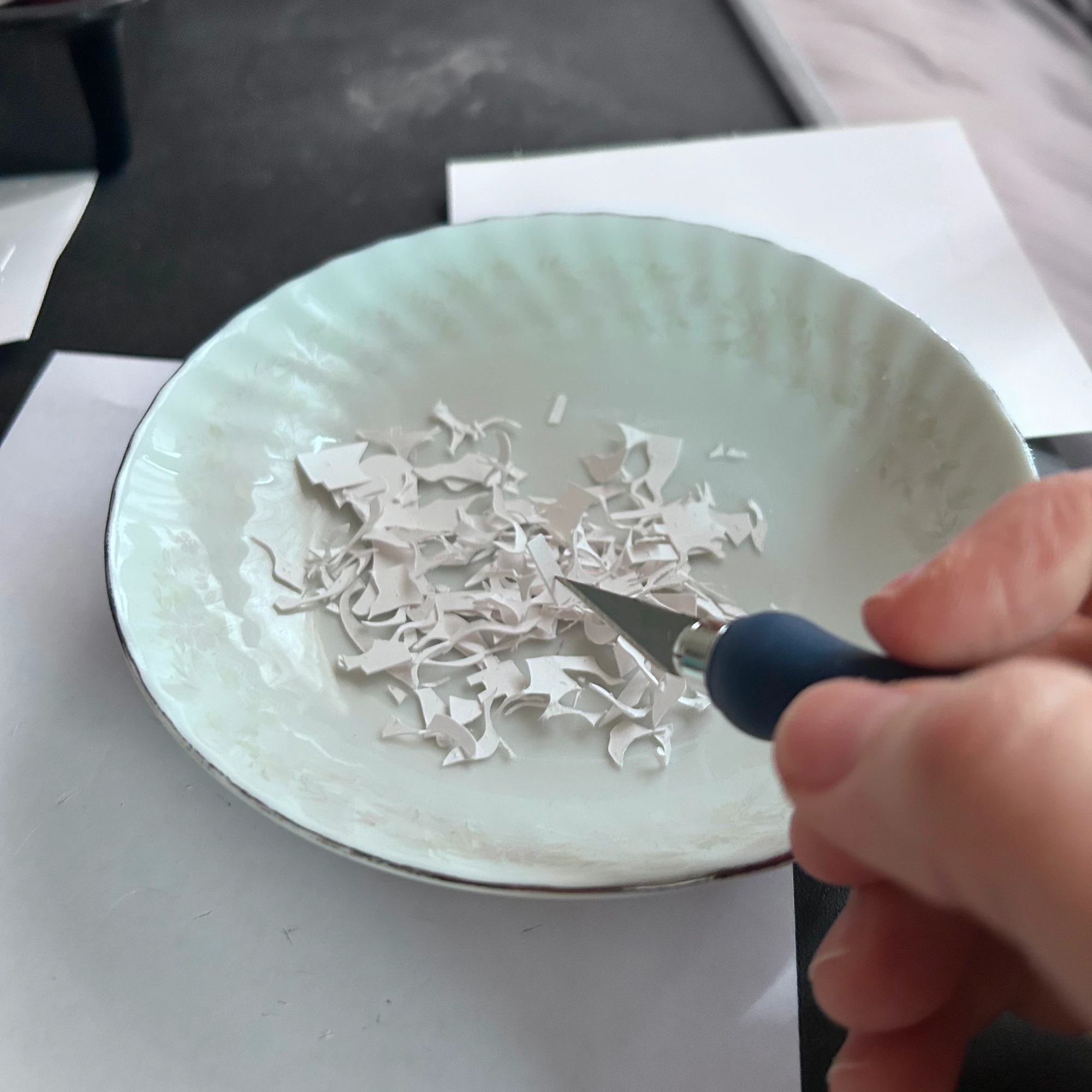 Little scraps of cut paper in a bowl.